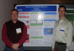 Picture of myself (left) and Carson (right) standing in front of a poster.