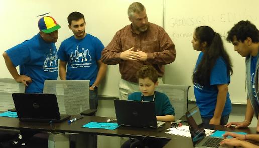 Chase, Vib, Eduardo, and myself are gathered around a computer on Discovery Day 2016 at GSU
